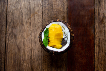 Blue spirrulina smoothie with flakes and chocolate in coconut on rustic background.