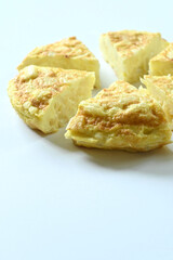 Spanish omelet cut into pieces on white background with copy space