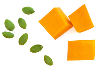 Pumpkin pieces isolated on white background. Pumpkin cubes with green seeds. Top view. Flat lay