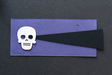 skull and crossbones on black and purple paper