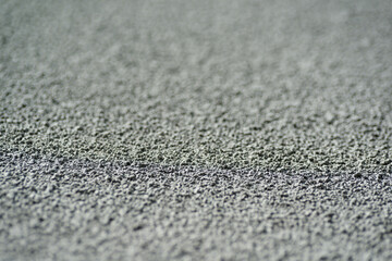 Macro texture details of brick wall roughcast painted grey. Shallow depth of field.