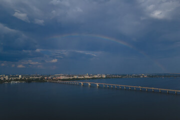 Fototapeta premium Beautiful double rainbow in the city after the rain. Photo from the drone. Rainbow against the blue sky