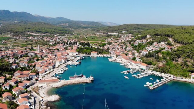 Drone shot on the Croatian resort island of Hvar in the Adriatic Sea. View from the drone to the port. Boats and ships on the shores of the Adriatic Sea in Croatia. Mountains on the island of Hvar. 