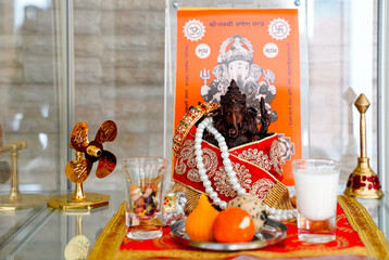 Ganesh Chaturthi Puja  at home.Prepare Laddu and milk , prayers for happiness and peaceful.Ganesh Hindu god statue on Hindu picture background.