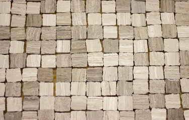 background mosaic of small stone blocks of uneven shape of gray color for the design of walls and floors in the interior close-up