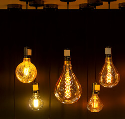 Obraz na płótnie Canvas stylish vintage round spiral light bulbs hanging group glow