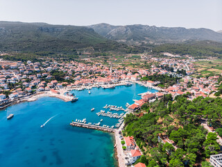 Drone shot on the Croatian resort island of Hvar in the Adriatic Sea. View from the drone to the port. Boats and ships on the shores of the Adriatic Sea in Croatia. Mountains on the island of Hvar. 