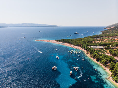 Drone shot at Zlatni Rat beach on the island of Brac in Croatia. Kosa from the center of Bol on the southern coast of the Croatian island of Brač, in Splitsko-Dalmatinska County. People swim - Powered by Adobe