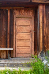 Old Russian door to the house with peeling paint and wooden steps. Vertical image.