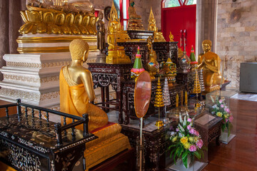 Altar with figurines and other decorations in Buddhist temple. Beautiful carved tables.