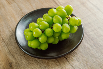 Shine muscat green grapes on a black plate