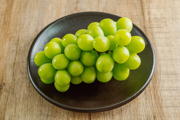 Shine muscat green grapes on a black plate