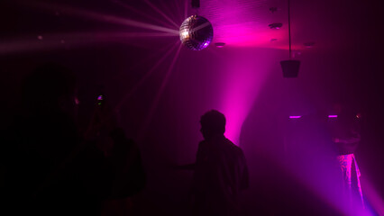 Party atmosphere with disco ball. Light beams reflecting from a disco ball. Nightlife concept. Space for text.