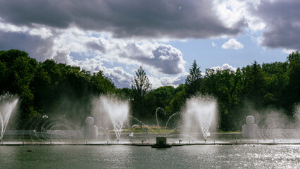 Water from the fountain. Top of high water stream of fountain behind cloudy sky. Fountain in river against dramatic sky. Cityscape view.