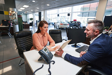 Attentive female customer studying the details in contract