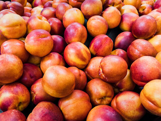 Fototapeta na wymiar Georgia peach harvest. Group of fresh ripe peaches on display at farmers market.