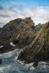 Black slate cliffs crossed by veins of golden pyrite