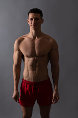Happy to be fit. Athletic man grey background. Shirtless man in sports shorts. Sportsman