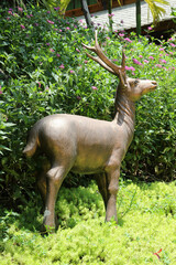 A deer statue is standing in the garden.