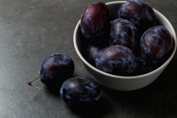 Fresh plums. Fruits. On a dark background. Copy space.