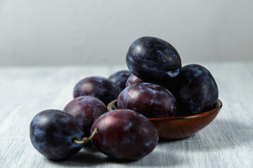 Fresh plums. Fruits. On a white wooden background. Copy space.