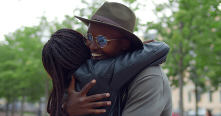 Fototapeta premium Afro-american happy young couple hugging and laughing outdoors.