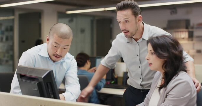 Woman manager leading diverse team meeting in small business. Three people working around computer late at night