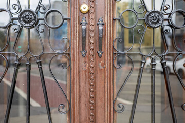 Close up view of Art Deco style door, reflections of street outside. 