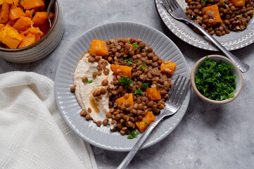 Vegan healthy food. Lentils and butternut squash with houmus and green herbs, clean eating concept