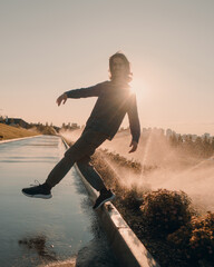 cheerful young guy smiles and runs away from water splashes