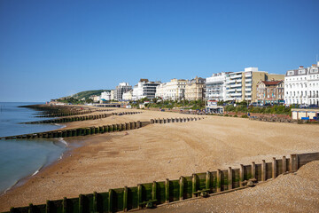 Obraz premium Eastbourne beach and Hotels, East Sussex, England. A summertime view across the seafront of the English seaside town with South Downs in the distance.