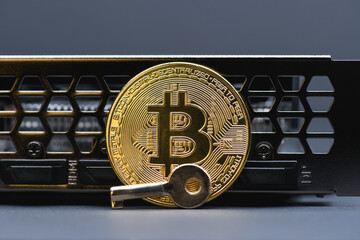 Golden bitcoin and key on gray background,  close up. Crypto currency. Bitcoin mining concept