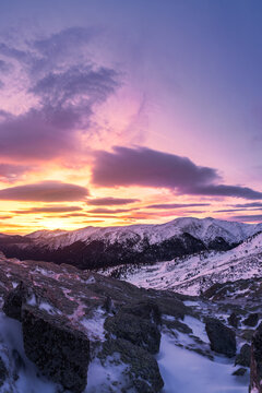 Snowy mountains under colorful sky at sunset