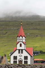 Sandavágur (Sandy Bay) Church with its distinctive bright red roof, Vagar Island, Faroe Islands.