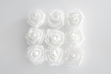 White flowers on the white background. White roses. Minimalist design. Birthday, women's day, anniversary, wedding. Top view, flat lay.
