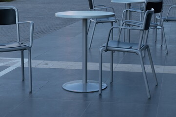 a round table with chairs are standing on the street