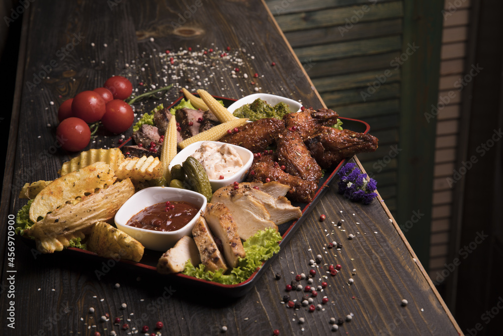 Sticker Meat assortment of fried chicken wings, beef, and pork decorated with lettuce, cherry tomatoes