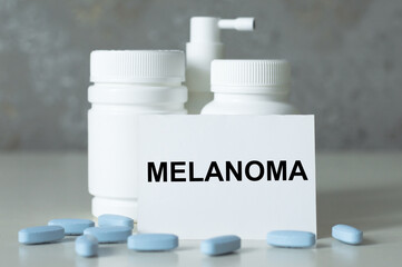 white card with the text MELANOMA on the table next to the medicine jars