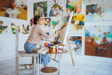 Fototapeta asian female artist painting on canvas doing some art projects on her studio workshop obraz
