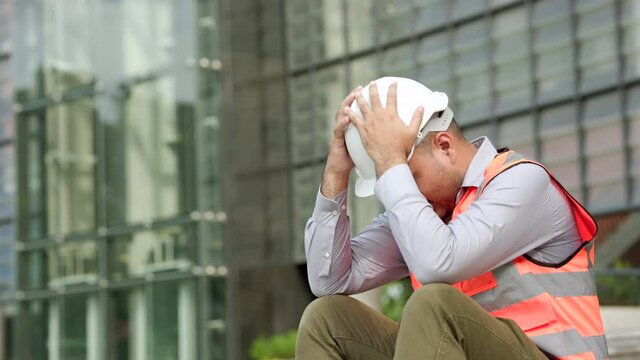 Worker hard working at construction site he tired and disconsolate. The civil engineer made a mistake, he was very stressed. Damage the structure of the building causing a breakdown.
