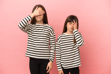 Little sisters girls isolated on pink background with surprise and shocked facial expression