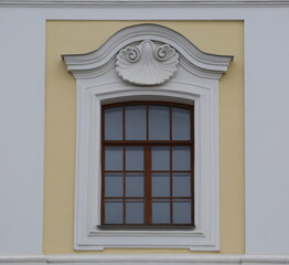 An old multi-section window in a yellow-and-white wall