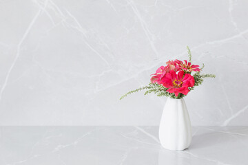 pink zinnia flowers on vase on marble background