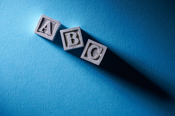 wooden block with letter abc on blue background