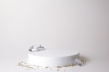 White podium on the white background with diamonds and small crystals. Podium for product, cosmetic presentation. Creative mock up. Pedestal or platform for beauty products.