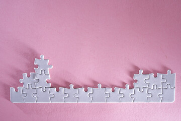 close up jigsaw puzzle on pink background