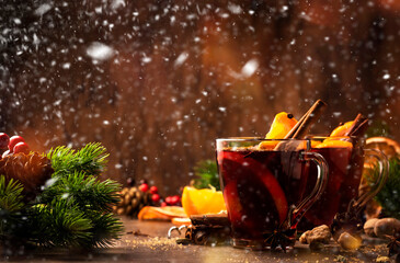 Winter hot mulled red wine in glass cup on wooden rustic table. Traditional Christmas or New Year...