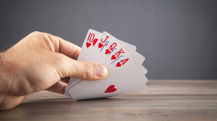 Male hand holding playing cards.