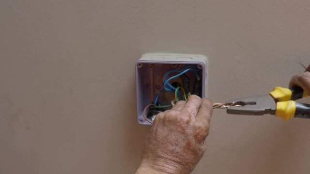 Electrical plug repairs and extension cords by a professional electrician. with equipment such as drills, wires, fuses, floating boxes and conduit wiring. installing wall switches and sockets.
