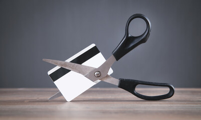 Black scissors cutting a credit card.